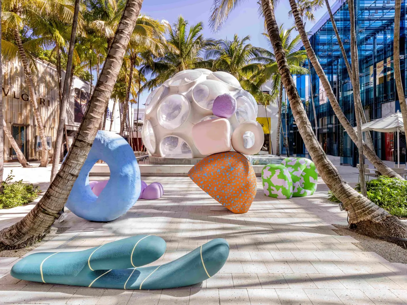Colourful sculptures by Alex Proba installed between palm trees in the Miami Design District