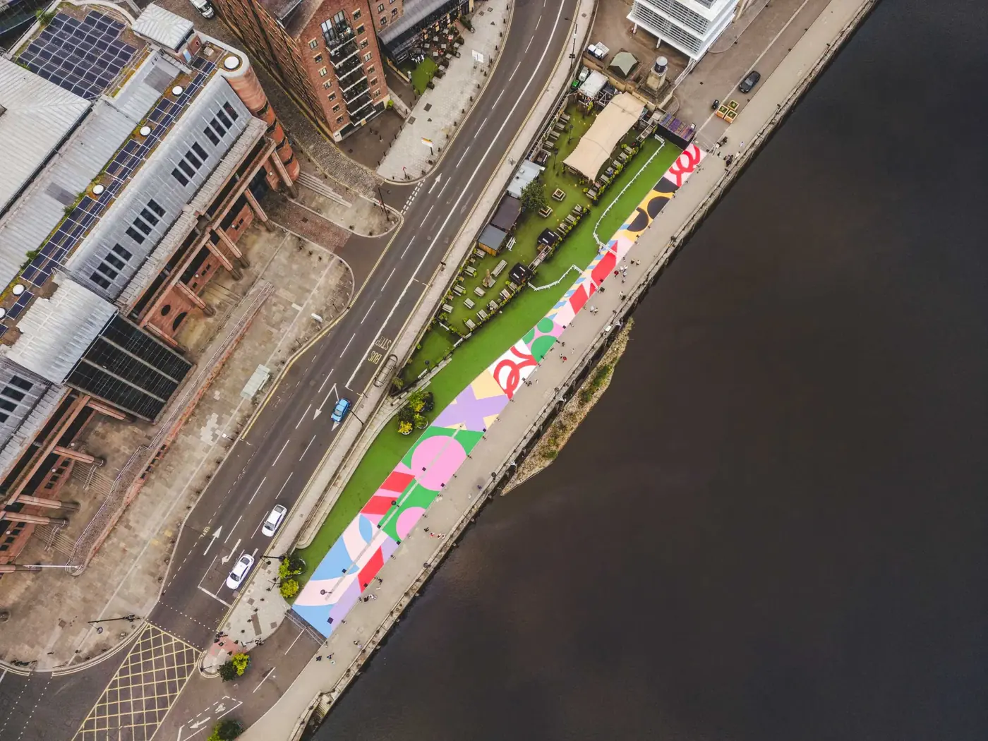 Aerial view of Andy Welland's 90-metre Loose Ends 300 mural painted on Newcastle Quayside in blue, yellow and pink