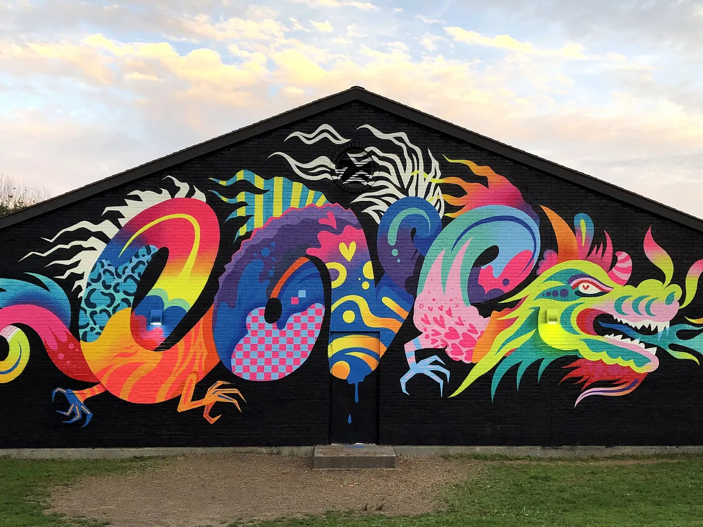 Jason Naylor mural at POWWOW! Worcester showing a neon-coloured Chinese dragon spelling the word LOVE on a black gable wall