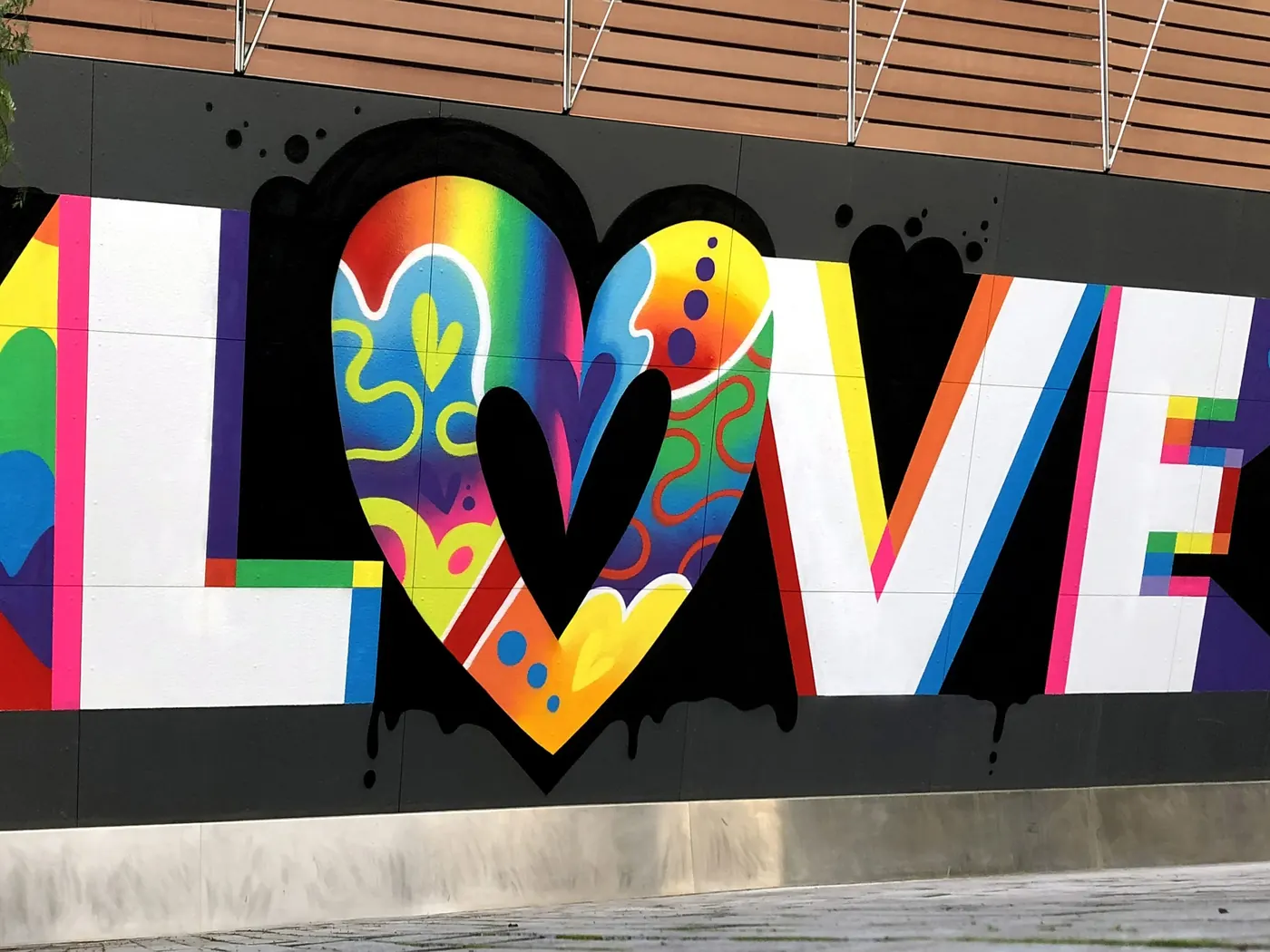 Jason Naylor mural at The William Vale in Brooklyn, a large LOVE wordmark with a rainbow heart dripping black paint