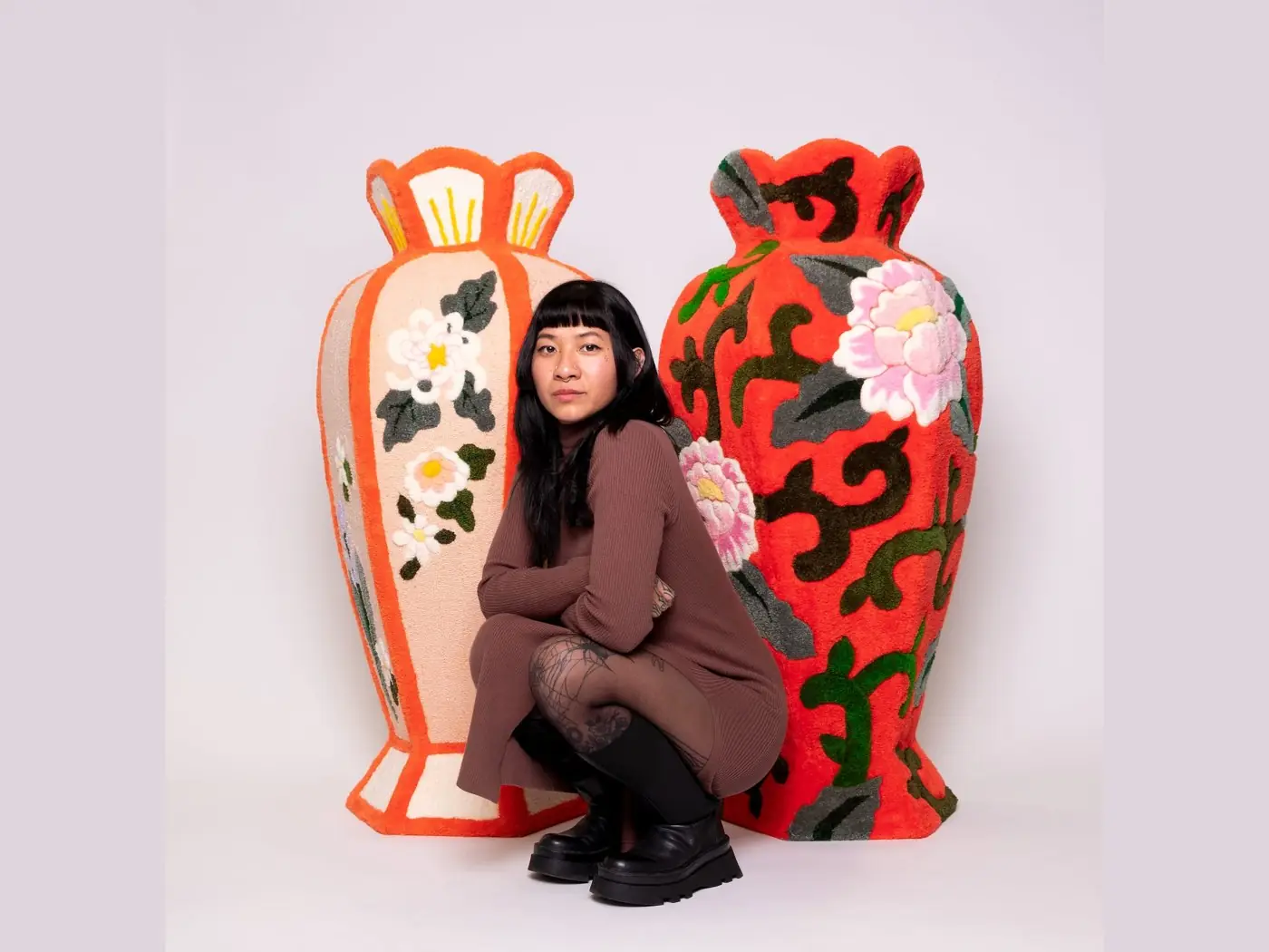 Shishi San crouching between two of her large tufted vases from the Fluffy Collection